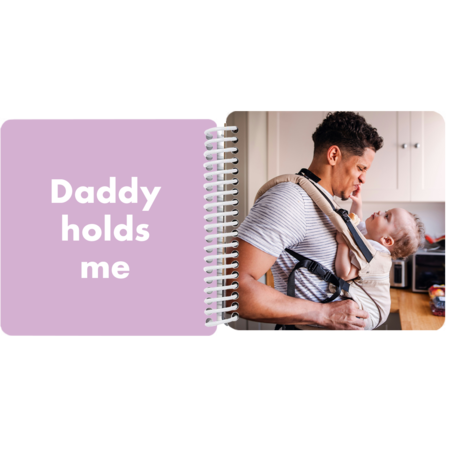 Dad carrying baby in a carrier in a personalized Daddy and Me board book with the message "Daddy holds me"
