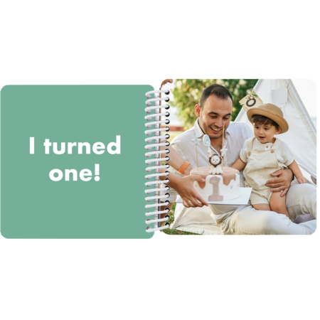 Child celebrating a first birthday with a cake in a personalized Year in Review board book with the milestone "I turned 1"
