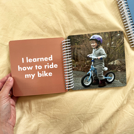 Girl riding a bike in a personalized Year in Review board book shared by a customer
